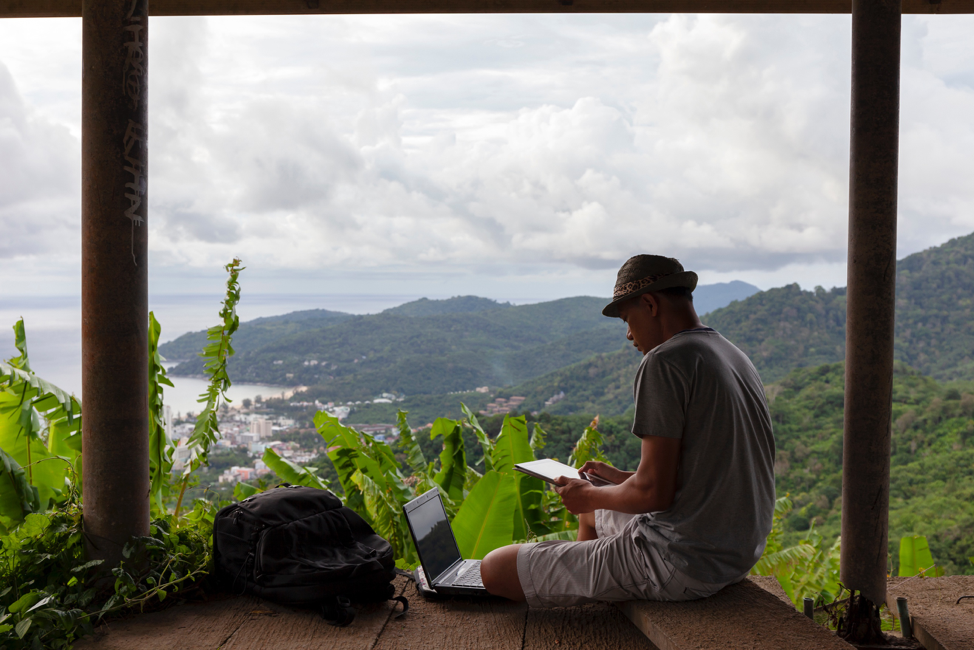 Man working on a laptop in the jungle
