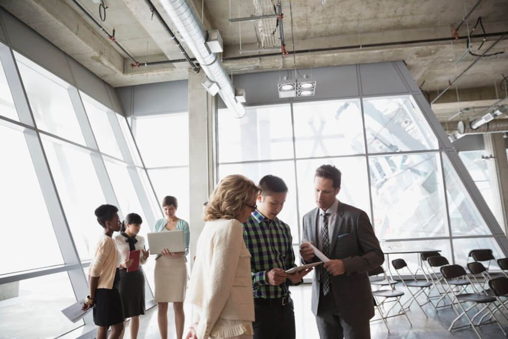 Group of business people with technology talking in office building