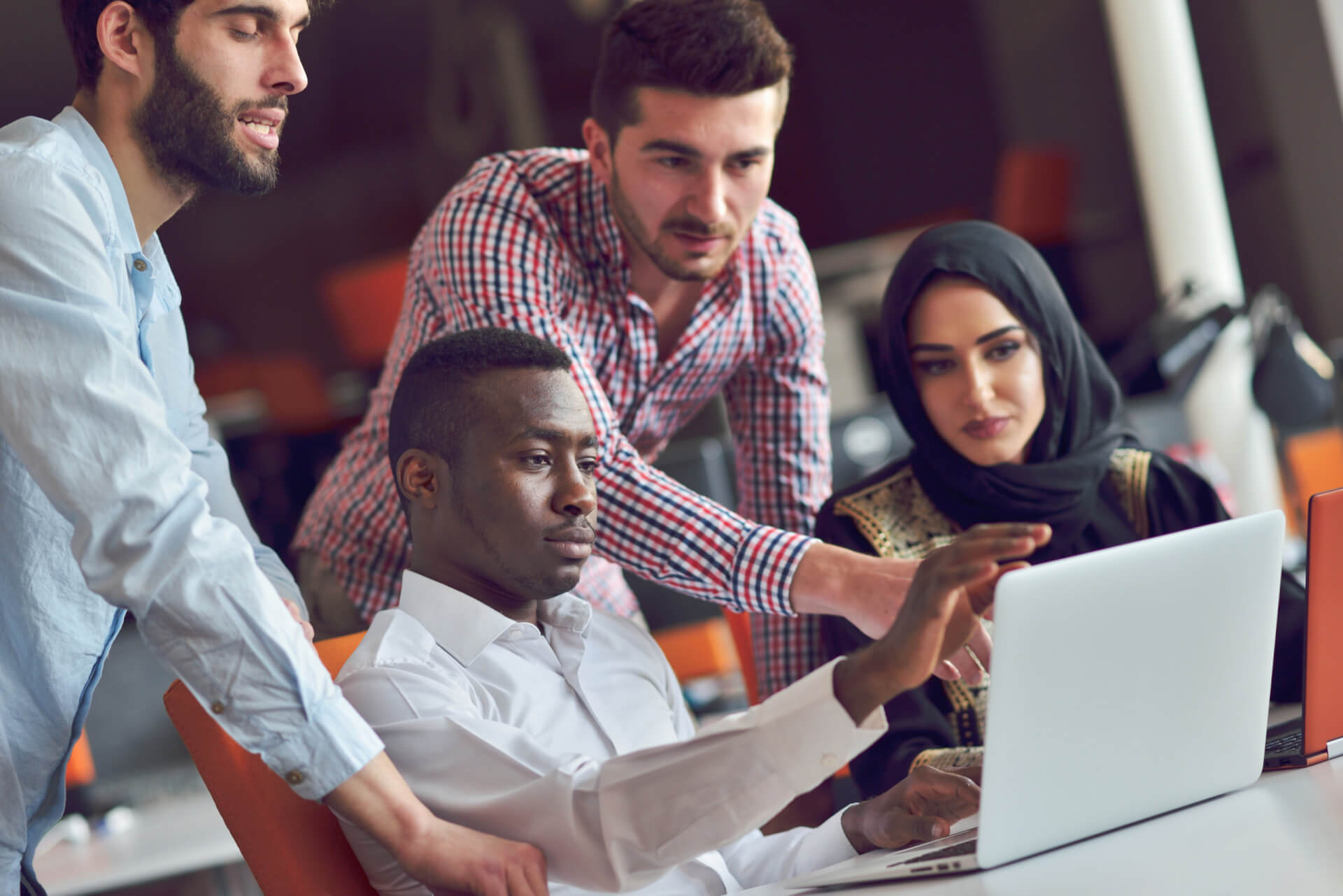 Multiracial contemporary business people working connected with technological devices like tablet and laptop, talking together - finance, business, technology concept