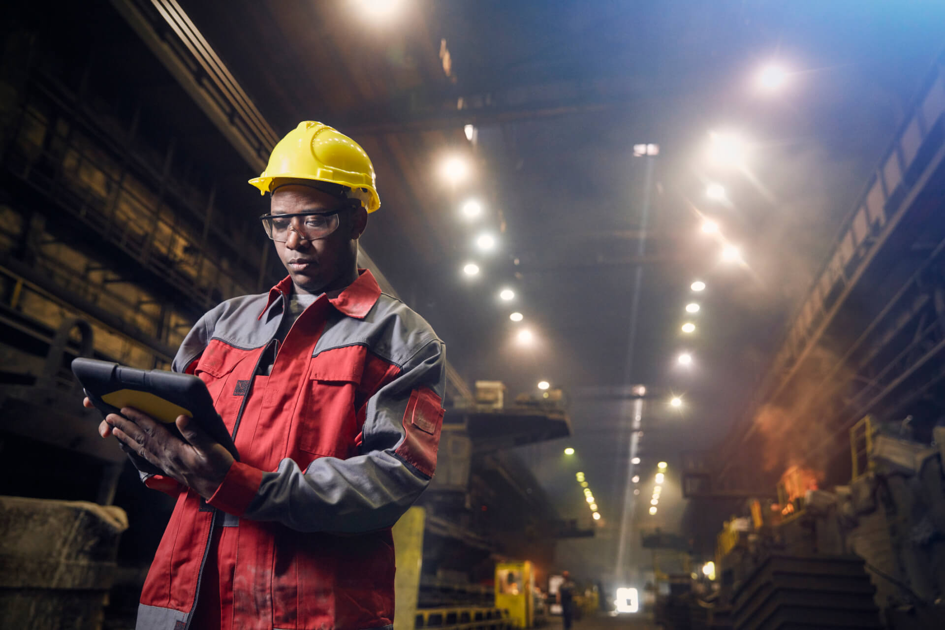 Steelworker using digital tablet in steel mill